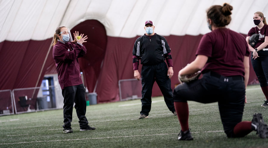 Coach Mel Lee coaching with a mask on in the dome